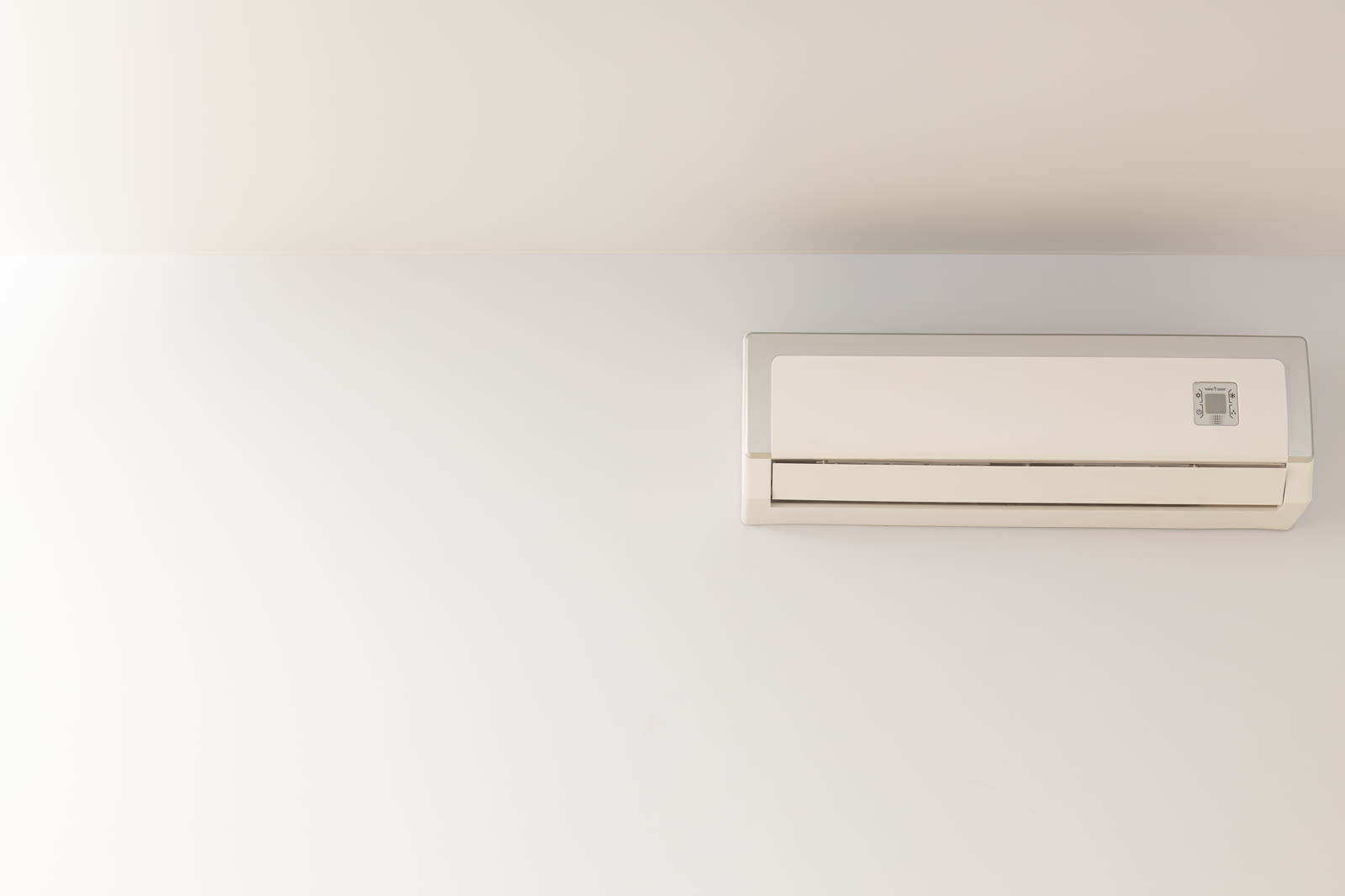 Ductless mini split indoor unit mounted high on a bedroom wall